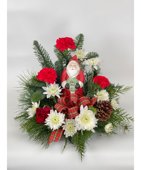 Santa's Treasure statue with evergreens and red and white flowers