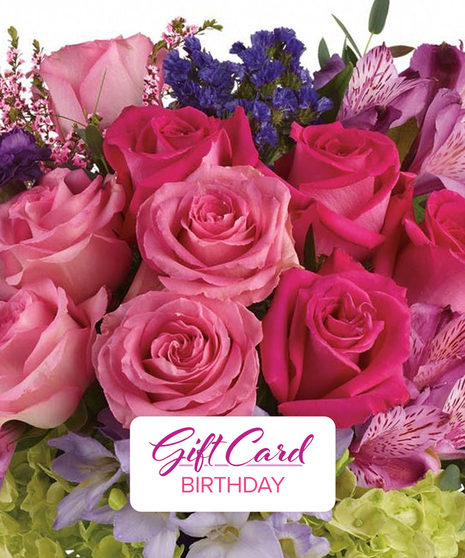 Bouquet of pink roses next to a gift with a happy birthday card