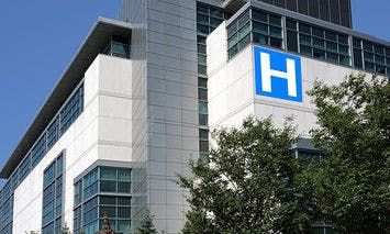 A modern, multi-story hospital building with a large blue 